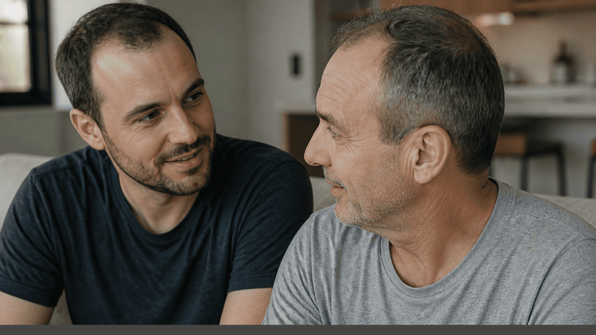 Father and son sitting together on a couch talking